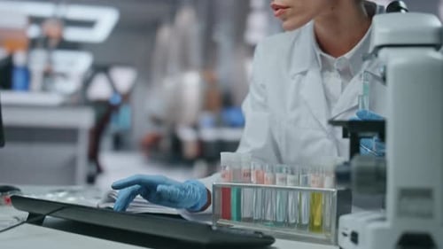 Biotechnological Researcher Typing Computer Developing Vaccine in Lab Close Up