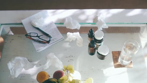 Medicine, glass of water and top view of pills on table in home for health, wellness or care
