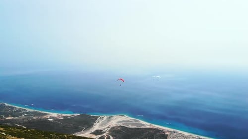 Extremer Gleitschirm fliegt gegen klaren blauen Himmel Sonnenstrahl scheint in die Kamera