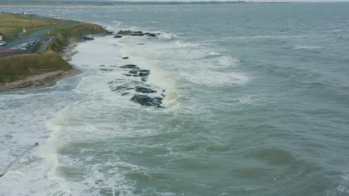 Aerial view of waves crashing against rocks along the coastline during a storm.
Drone Footage.