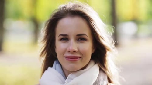 Smiling young woman with hair in autumn park