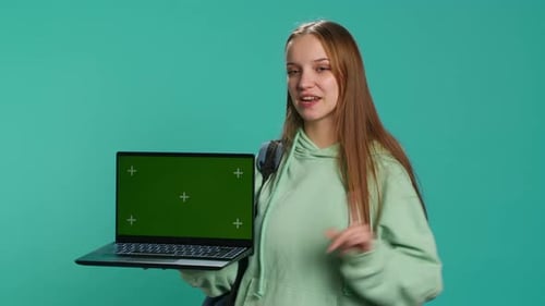 Smiling Woman Presenting Laptop with Green Screen Display