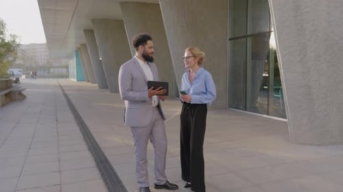 Business Colleagues Discussing Data Outside Modern Office Building