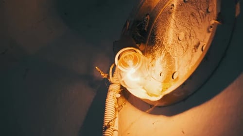 Glowing Lightbulb on Wall in Dark