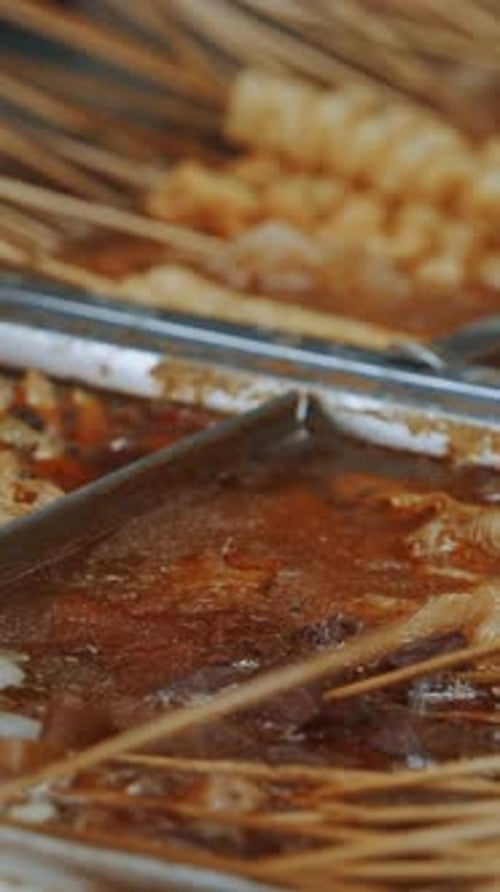 Skewered Snacks Simmering in Broth
