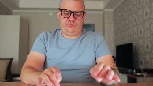 Man Types on Keyboard at Desk in Home