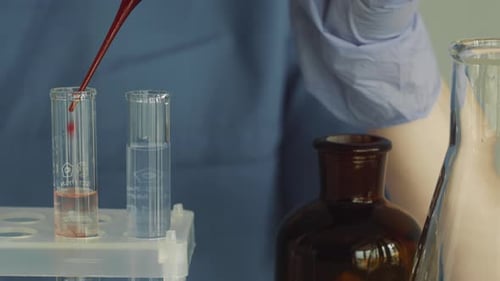 Lab Technician Adding Liquid to Test Tube