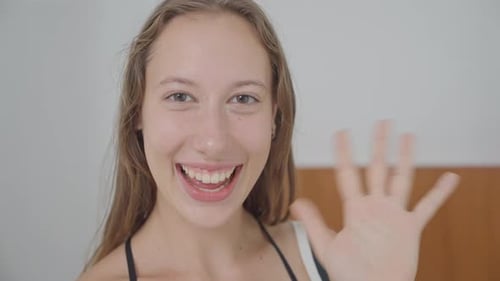 Young Adult Woman Smiling and Waving Hello