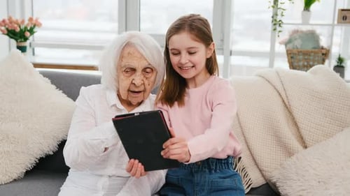 Grandmother and Child Using Tablet Together Indoors