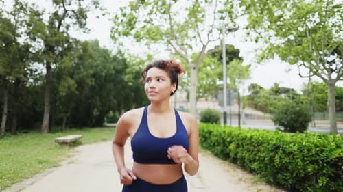 Young Sporty Woman Running in Slow Motion in a Park