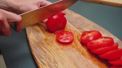 Bright Red Tomato Sliced on Wooden Cutting Board