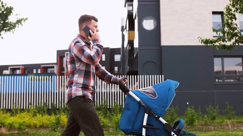 Family Leisure and People Concept - Father with Baby in Stroller Walking