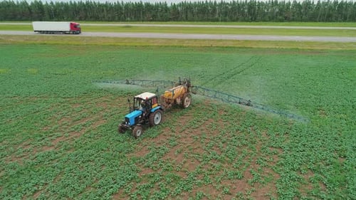 Aerial View of a Tractor Machine Spraying the Field with Pesticides Farm Machinery Spraying the