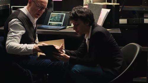 Man and Woman Looking at Tablet in Office