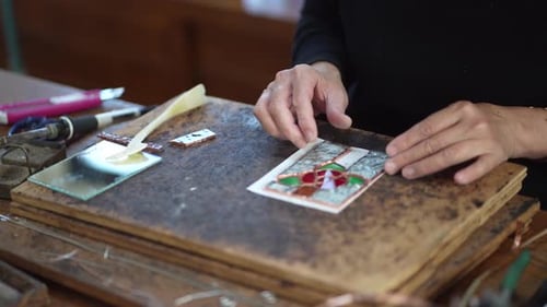A woman making a stained glass work