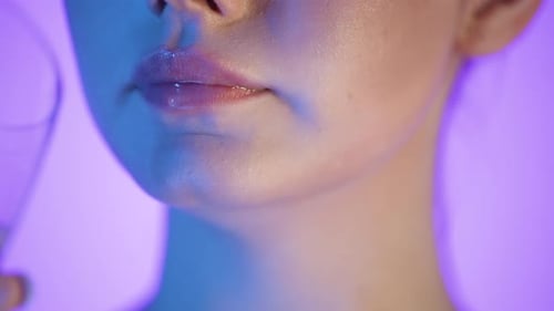 Close-Up Of Woman's Mouth With Wet Lips Drinking Water From a Glass, Studio Shot