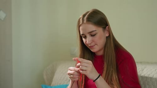 Woman Crafting at Home, Crocheting Red Yarn