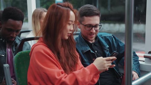 People Riding Public Transportation Using a Smartphone