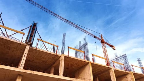 Subiendo a la parte superior de la construcción con barras de refuerzo de metal. Vista de ángulo bajo en el brazo de la grúa
