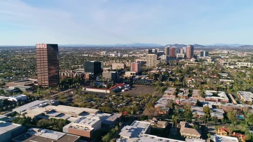 Aerial of downtown phoenix on a sunny day with blue sky, farsighted to mountains