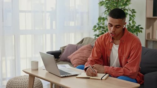 Young Adult Working from Home on Laptop