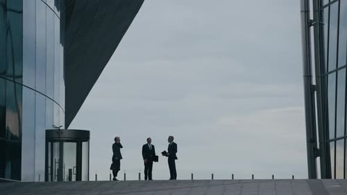 Businesspeople Meeting outside Modern Glass Office Building