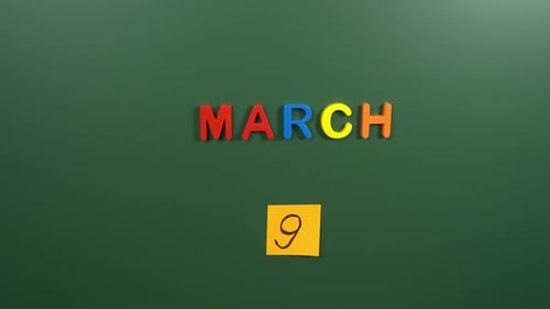 Hand sticking a sticker 9 March calendar day on school board. 9 date of March. Ninth day March