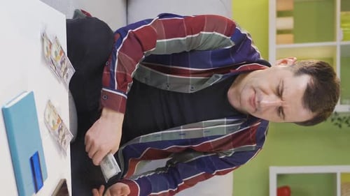 Man Counting Money at Table Indoors