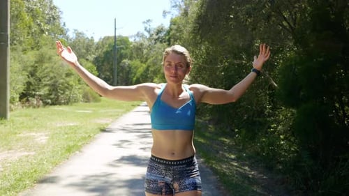 Athletic Woman Stretching Arms Outside on Path