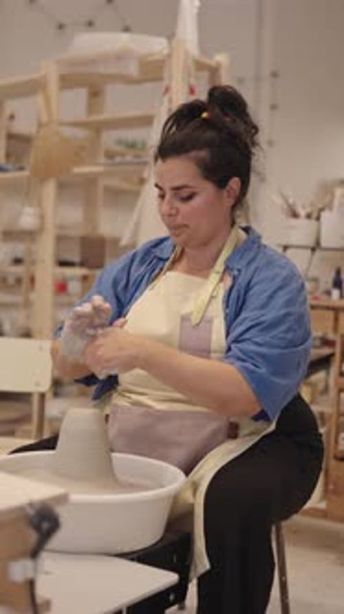 Woman Shaping Clay on Pottery Wheel in Studio