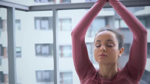 Woman Meditating on Balcony in Lotus Pose