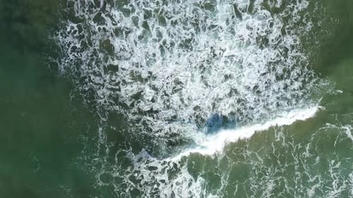 Aerial view of dangerous ocean waves approaching the coast by drone