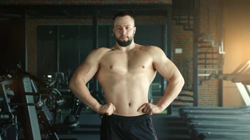Handsome Athletic Young Man with Naked Torso Hands on Waist Standing in Gym