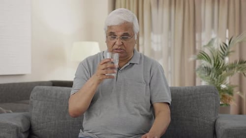 Sick Indian old man taking medicine
