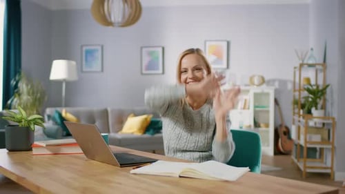Die
schöne, fröhliche Blondine macht eine lustige Tanzroutine, während sie an ihrem Schreibtisch im Wohnzimmer sitzt. Ha