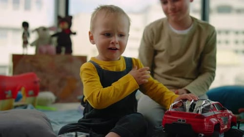 Brothers Playing with Toy Car Together Indoors