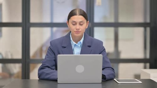 Young Woman Works at Laptop in Modern Office