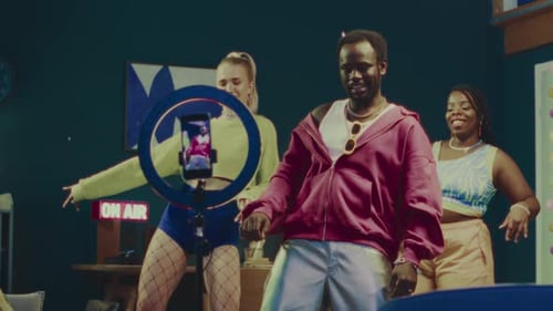 Amigos multiétnicos que se divierten mientras bailan en casa y transmiten en vivo