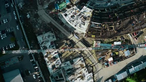 Top view of construction crane and colorful buildings of city. Stock footage. Construction site