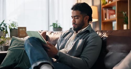 Man Relaxing on Couch Using Tablet Device