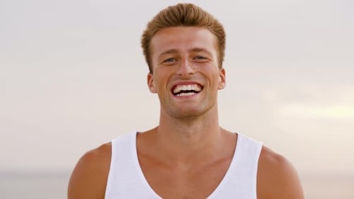Happy Young Man Smiles at the Beach