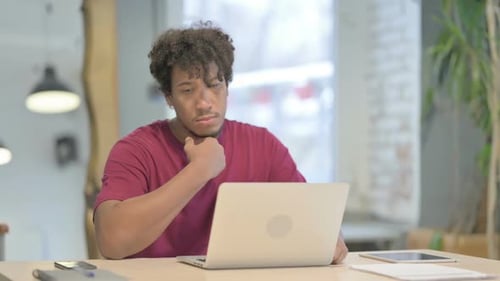 Young Adult Typing on Laptop at Desk