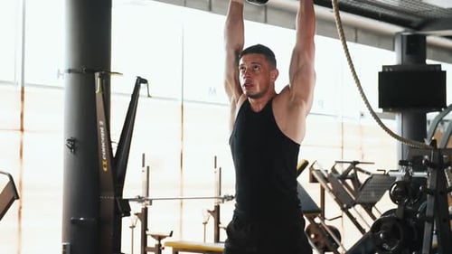 Langhantel heben. Junger sportlicher starker Mann in schwarzer Kleidung hat einen Trainingstag im Fitnessstudio