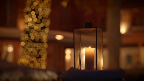 A Winter Evening with Holiday Lantern Candle and Bokeh Lights Creating a Cozy and Festive Atmosphere