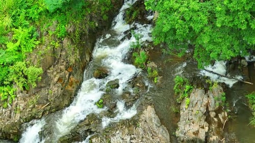 Breathtaking jungle waterfall from above. Lush green paradise.
