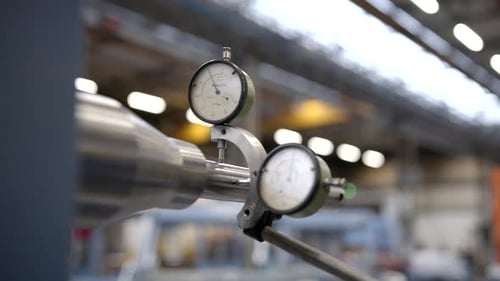 Outil de mesure de précision effectuant une mesure millimétrique longitudinale d'une barre en acier poli