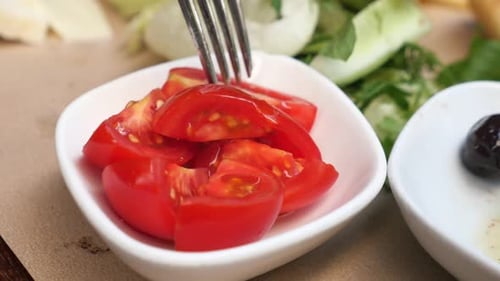 Cueillez à la fourchette des tranches de tomates cerises sur la table
