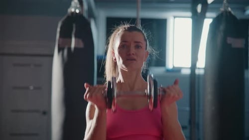 Woman Doing Overhead Press With Dumbbell in Gym