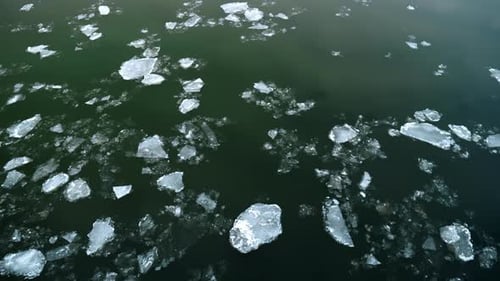 Ice Floes Drifting Downstream on River During Cold Winter Day