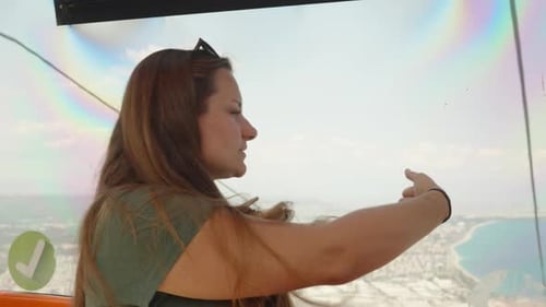 The young woman points to the beautiful views around. Walk in the funicular on the cable car. Sea an